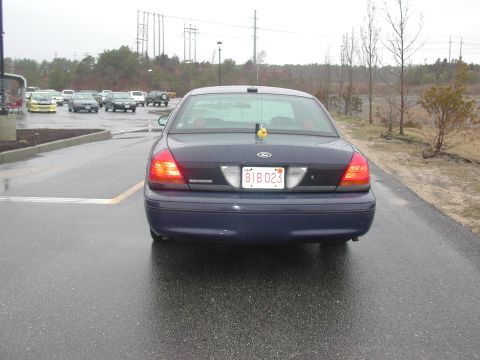 1999 Ford Crown Victoria - Rear view of a dark blue sedan with a yellow duck on the trunk.