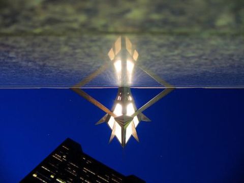 2000 Ford Crown Victoria - A reflection shows a building and a geometric light fixture against a dark blue sky.