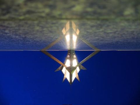 2000 Ford Crown Victoria - Illuminated geometric fixture with a reflection, set against a deep blue background.