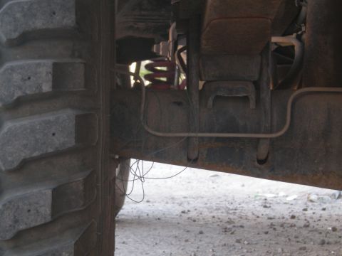 1993 Ford Bronco - Close-up view of a vehicle's undercarriage, showing suspension and a large tire.