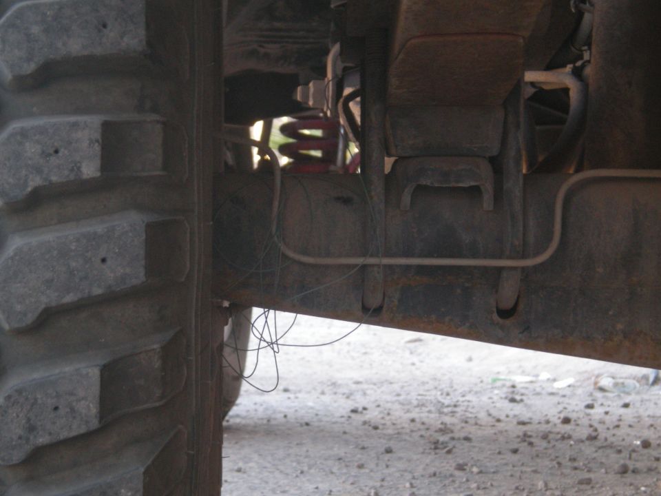 Undercarriage of a vehicle with a large tire and suspension components visible