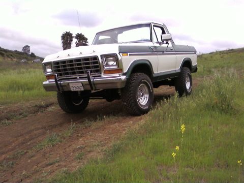 1978 Ford Bronco - This 1978 Ford Bronco, identified by its license plate, is shown off-road in a grassy, hilly landscape.