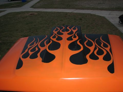 1979 Ford Bronco - Overhead close-up of the black tribal flame paint job on an orange hood, with the licks running symmetrically up and over the raised cowl s…