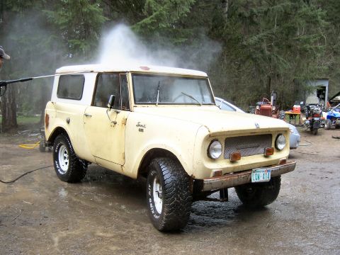 1966 International Scout 800 - A 1966 International Scout 800 is pressure washed in a driveway, showing its distinctive grille and body style.