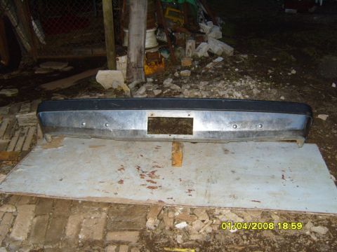 1989 Ford Bronco - Front bumper assembly, likely from a 1989 Ford Bronco, resting on a wooden board.