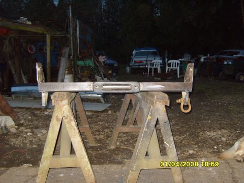 1989 Ford Bronco - A fabricated winch bumper assembly is displayed outdoors on sawhorses, with other vehicles visible in the background.
