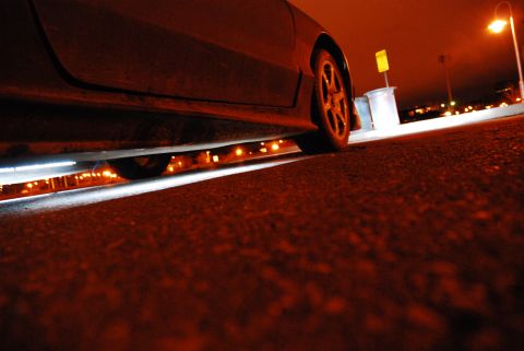 1993 Ford Probe - A car's side profile is visible at night, illuminated by underglow lighting and a street lamp.