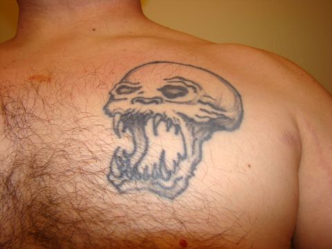 1989 Ford Bronco - A tattoo of a skull with its mouth open and sharp teeth is visible on a person's chest.