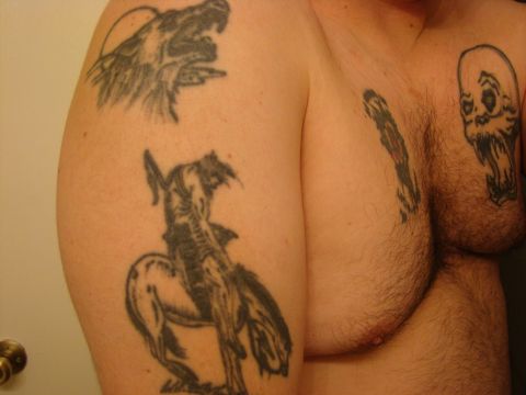 1989 Ford Bronco - This image displays several tattoos, including a wolf, a cowboy riding a horse, and a skull, on a person's upper body.