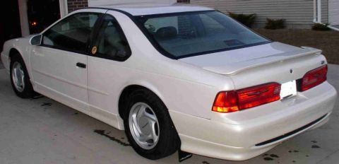 1994 Ford Thunderbird - The rear three-quarter view of a white 1994 Ford Thunderbird coupe is shown.