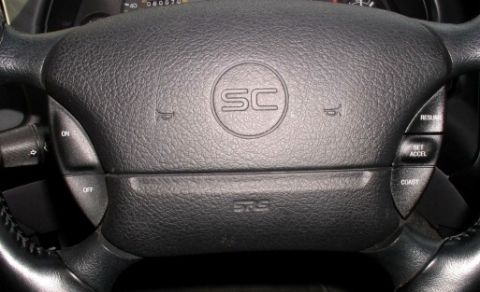1994 Ford Thunderbird - Interior view of a 1994 Ford Thunderbird SC steering wheel, showing cruise control and SRS airbag markings.