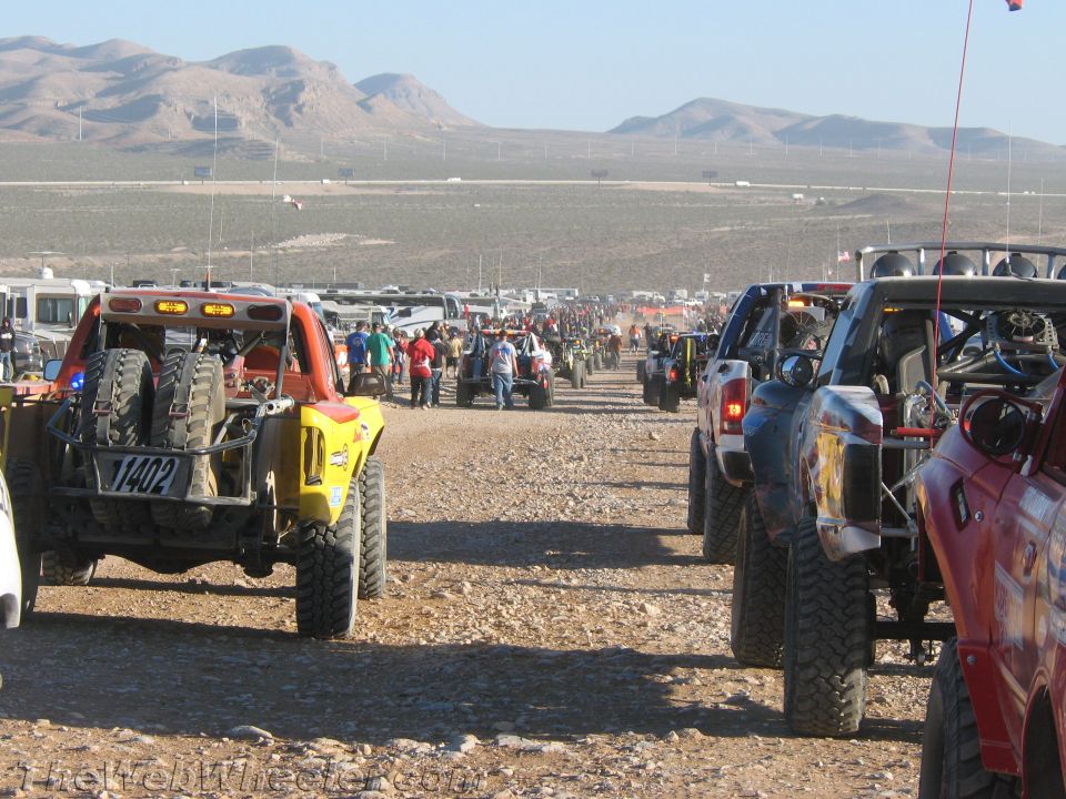 Two columns of off-road race vehicles staged on wide desert course