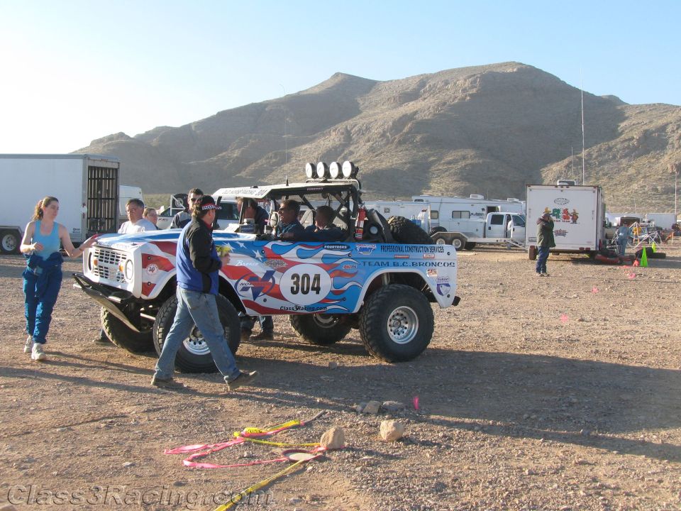 Patriotic number 304 early Bronco race truck with crew in desert pits