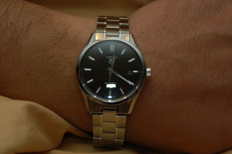 Wrist shot of a TAG Heuer Carrera watch with a black dial and metal band