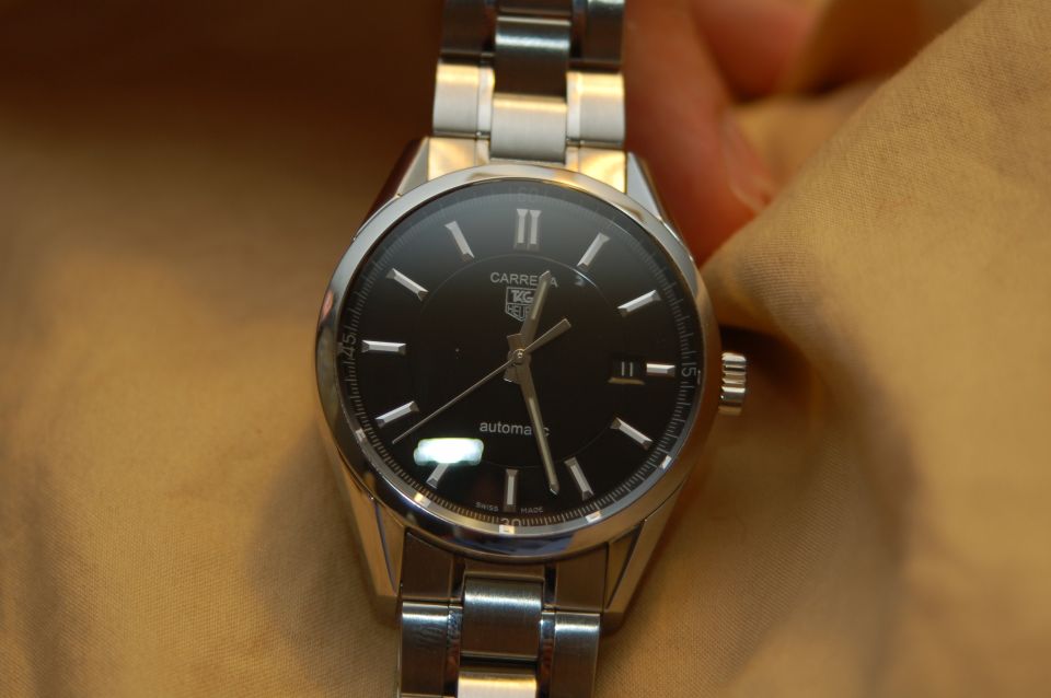 Black face watch with silver band and Roman numerals