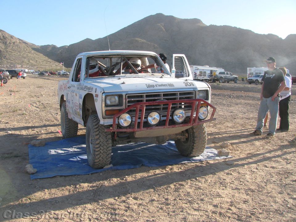 White off-road race truck number 306 with red bumper at three-quarter angle