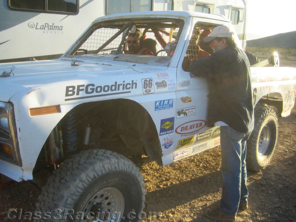 White race truck number 66 with BFGoodrich decal, person leaning in at pit