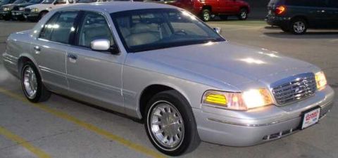 1999 Ford Crown Victoria - This sedan has a distinctive grille and headlight design, indicating a specific model year.