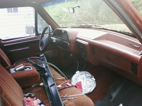1987 Ford F-150 - The interior of a 1987 Ford F-150 shows a cracked windshield and tools scattered across the seats.