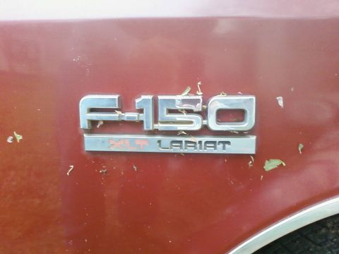 1987 Ford F-150 - Close-up of the F-150 XLT Lariat badging, indicating a specific trim level for the truck.