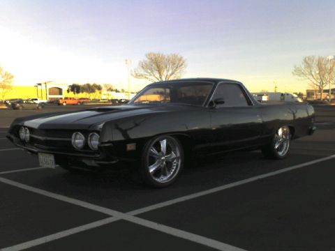 1970 Ford Ranchero - A black 1970 Ford Ranchero is parked in a lot under a clear sky.