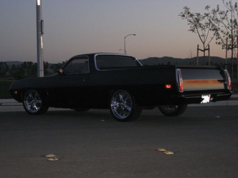 1970 Ford Ranchero - Rear view of a black 1970 Ford Ranchero with custom chrome wheels under a twilight sky.