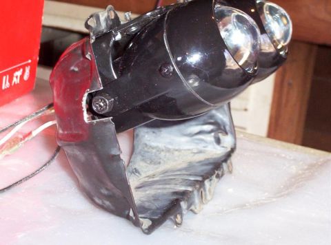 1995 Ford Probe - A damaged headlight assembly is shown, with visible wiring and a red plastic component.