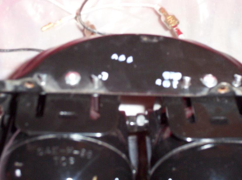 Close-up of two car headlights with wiring attached