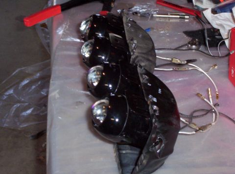 1995 Ford Probe - Car headlights with wiring are laid out on a table next to tools.