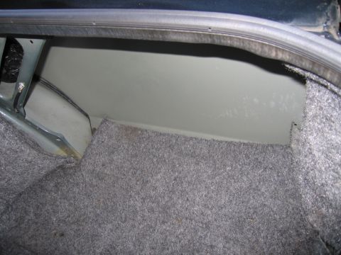 1991 Ford LTD Crown Victoria - The inside of a car's trunk shows the carpeted floor and the painted metal walls.