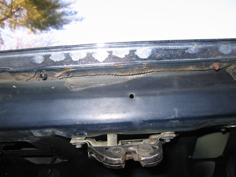 Close-up of a car's trunk latch mechanism and surrounding metal