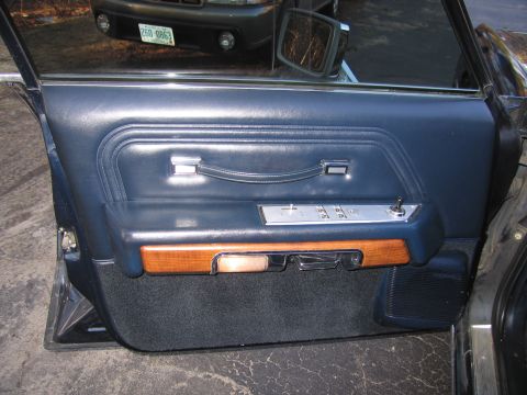 1991 Ford LTD Crown Victoria - View of the driver's side interior door panel, showing blue vinyl and wood accents. A second vehicle is visible outside.