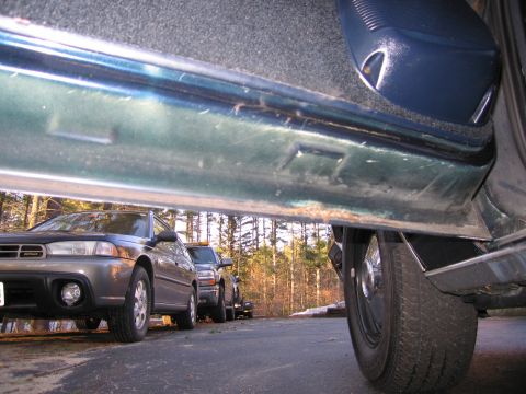 1991 Ford LTD Crown Victoria - A low-angle view from inside a vehicle shows the door sill and several other cars parked outside.