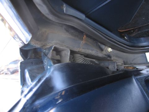 1991 Ford LTD Crown Victoria - Close-up view of the hood latch mechanism on a blue vehicle.