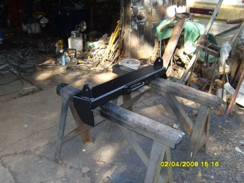 1989 Ford Bronco - A newly painted winch mount sits on sawhorses in a workshop environment.