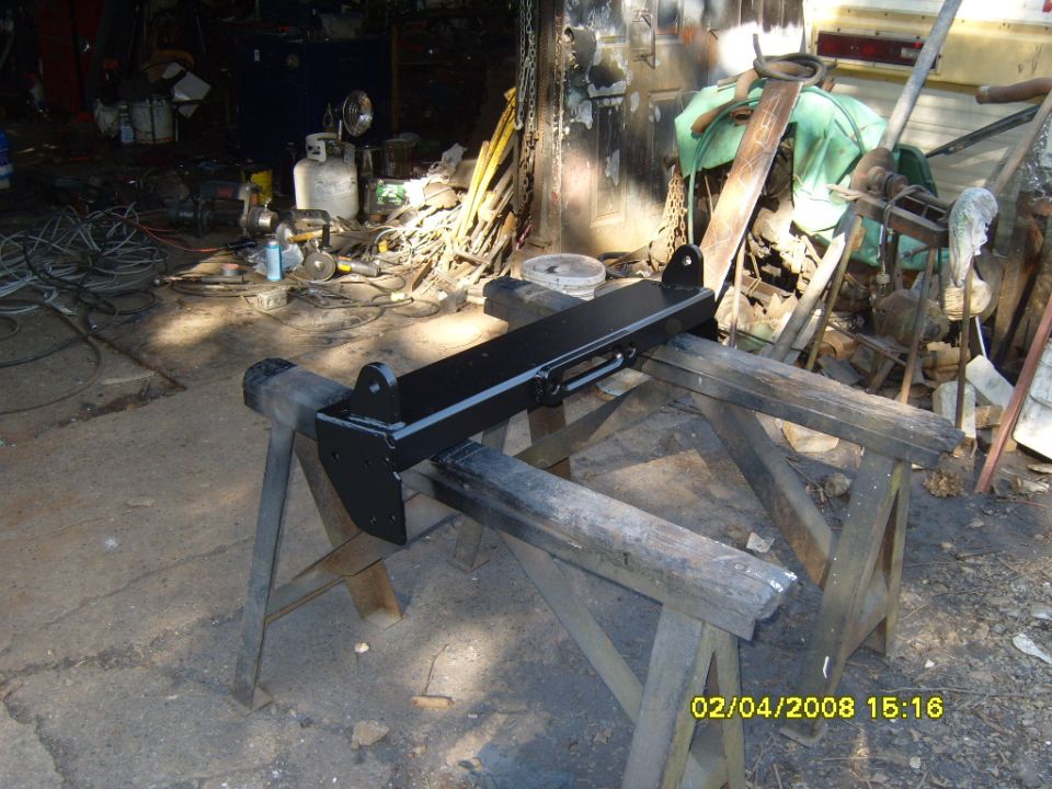 black winch mount on sawhorses in a cluttered garage