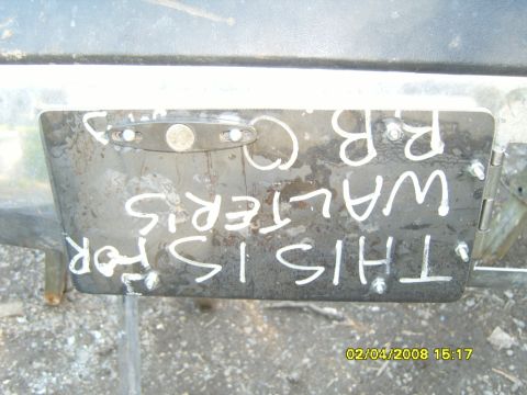 1989 Ford Bronco - Metal plate with handwritten text is bolted to a vehicle part.
