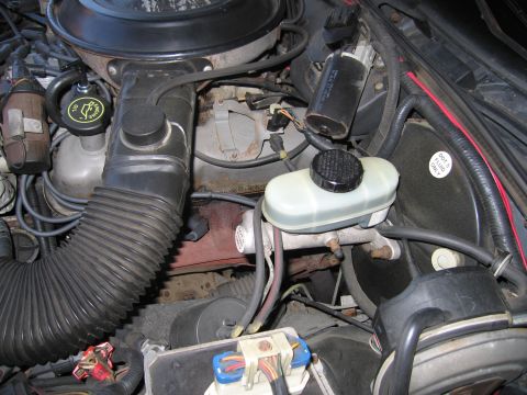 1991 Ford LTD Crown Victoria - Close-up of a vehicle's engine bay, showing the brake master cylinder and air intake system.