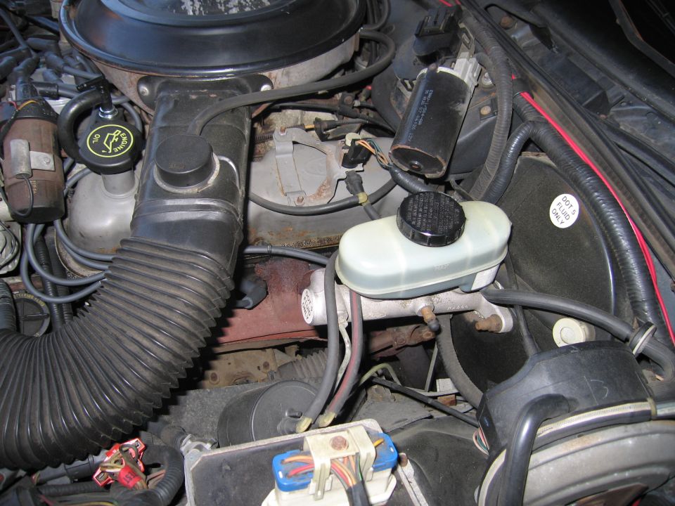 Engine bay with brake fluid reservoir and air intake hose