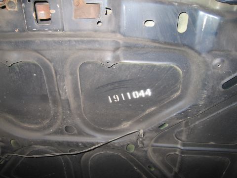 1991 Ford LTD Crown Victoria - The underside of a car hood shows stenciled identification numbers, but no clear year or model information is visible.