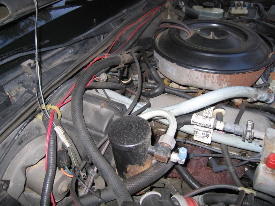 Engine bay with air filter housing, hoses, and wiring visible. A Motorcraft label reads VF-1939