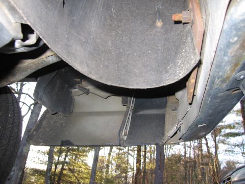 1991 Ford LTD Crown Victoria - Underside view of vehicle's front bumper and fender liner shows mechanical components.