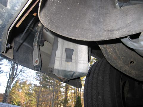 1991 Ford LTD Crown Victoria - Close-up of the fuel tank and surrounding undercarriage components of a vehicle.