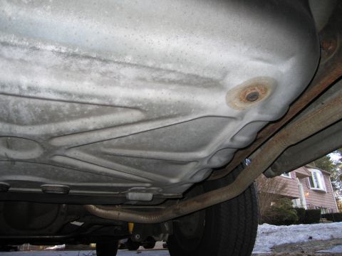 1991 Ford LTD Crown Victoria - The underside of a vehicle is visible, with a focus on the fuel tank and exhaust system.