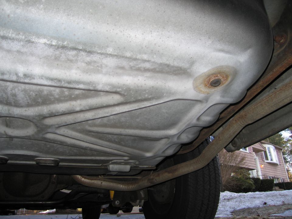 Underside of a vehicle showing the fuel tank and exhaust pipe