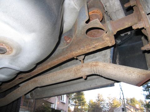 1991 Ford LTD Crown Victoria - Close-up view of the underbody, showing rusted exhaust and suspension parts.