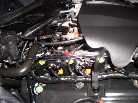 Close-up of a complex engine bay wiring harness with various connectors and tubes