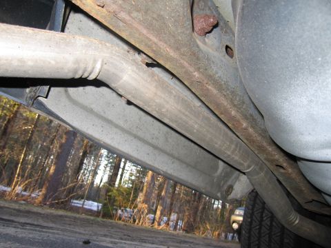 1991 Ford LTD Crown Victoria - A close-up shot of the undercarriage of a vehicle, showing the exhaust system and frame components.