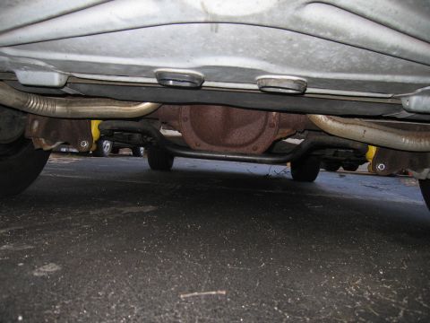 1991 Ford LTD Crown Victoria - Undercarriage view of a vehicle, focusing on the rear axle and exhaust system.