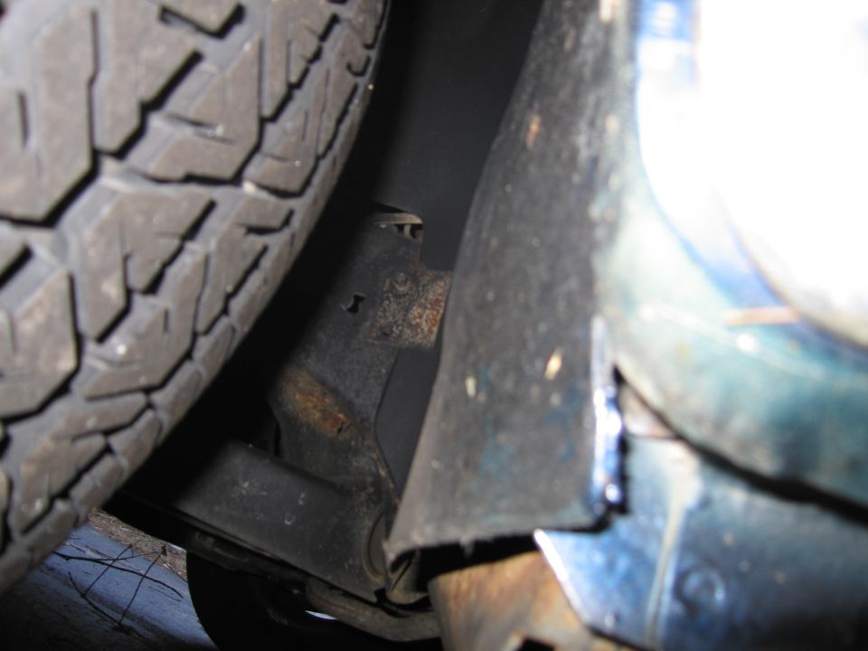Close-up of car's suspension components and tire tread
